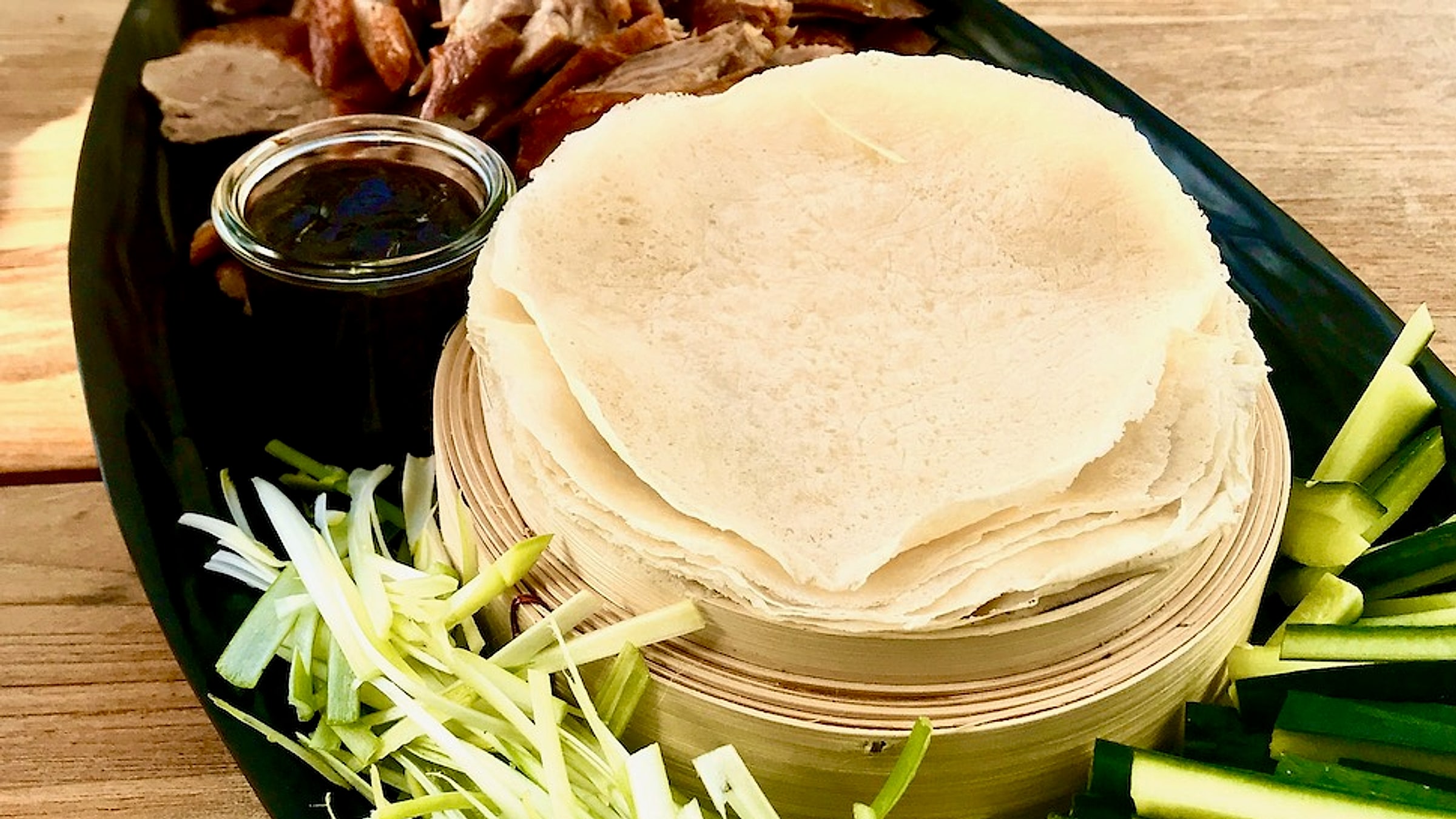 Peking duck served with thin pancakes, scallions, cucumber, and hoisin sauce — Beijing's signature dish
