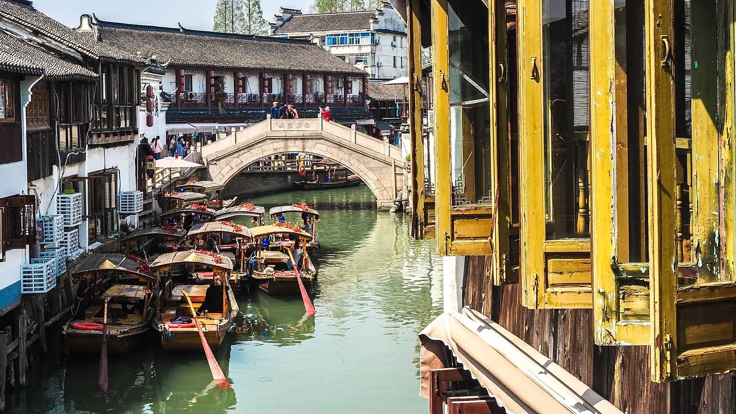 Zhujiajiao water town at blue hour with traditional white-walled houses and red lanterns reflected in the canal