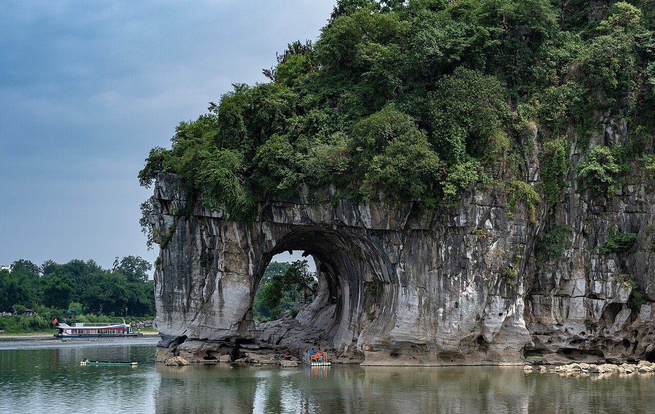 Elephant Trunk Hill — a 55-meter limestone karst formation shaped like an elephant drinking from the Li River, with the round Water Moon Cave visible underneath