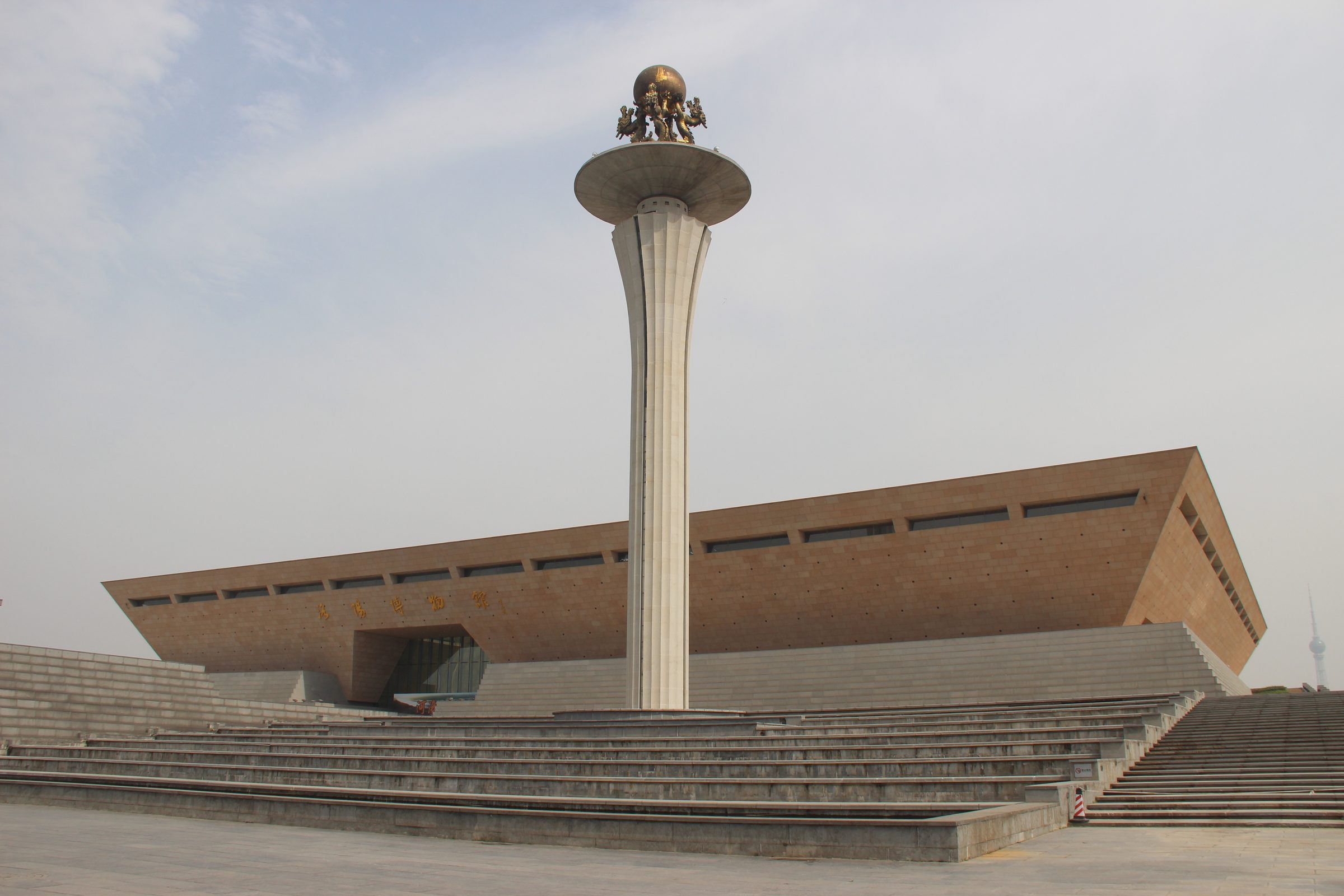 The new Luoyang City Museum building, a large modern structure with a stone facade and traditional Chinese architectural elements