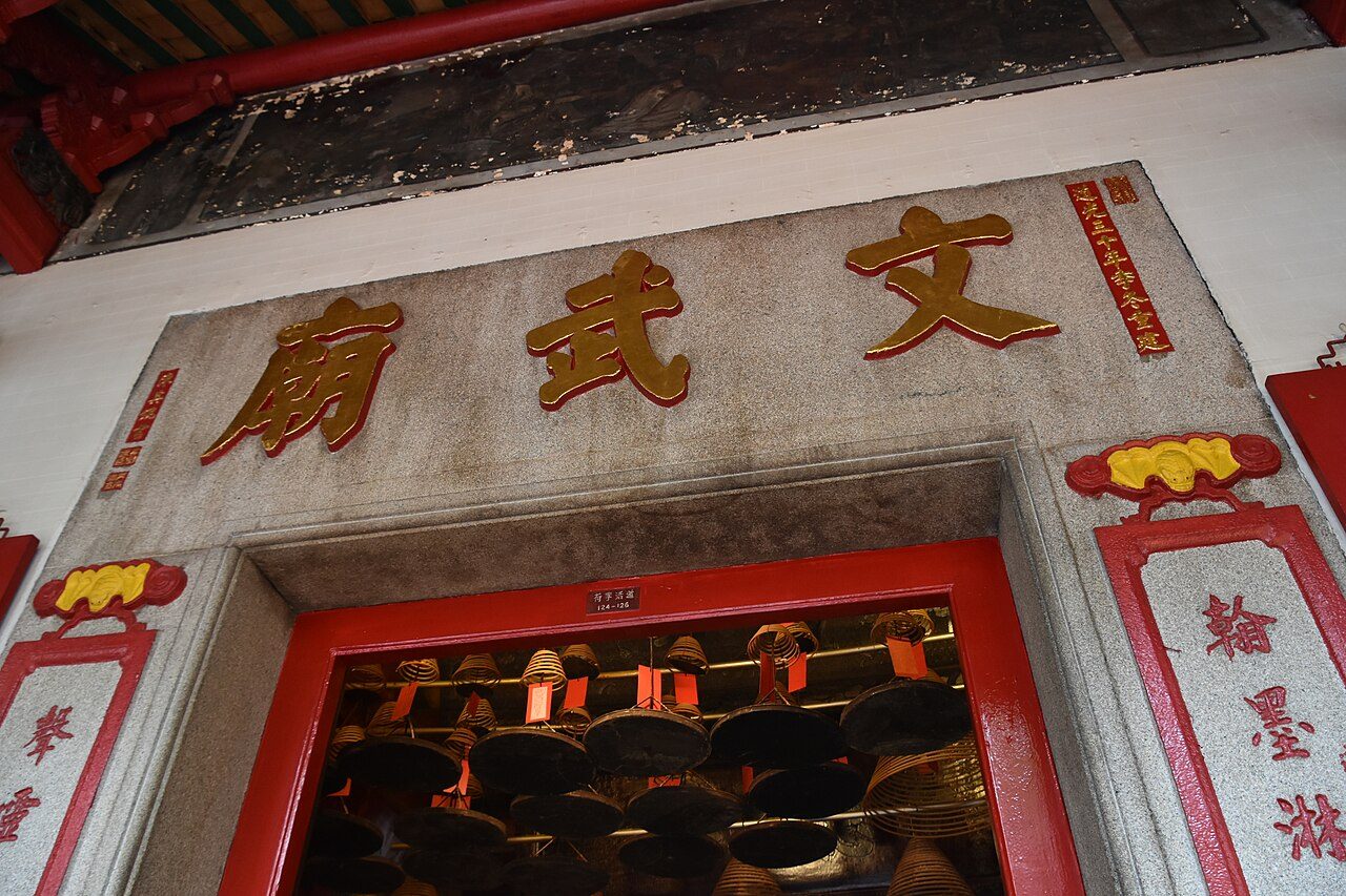 Interior of Man Mo Temple showing the hanging spiral incense coils and the altars to the gods of literature and war