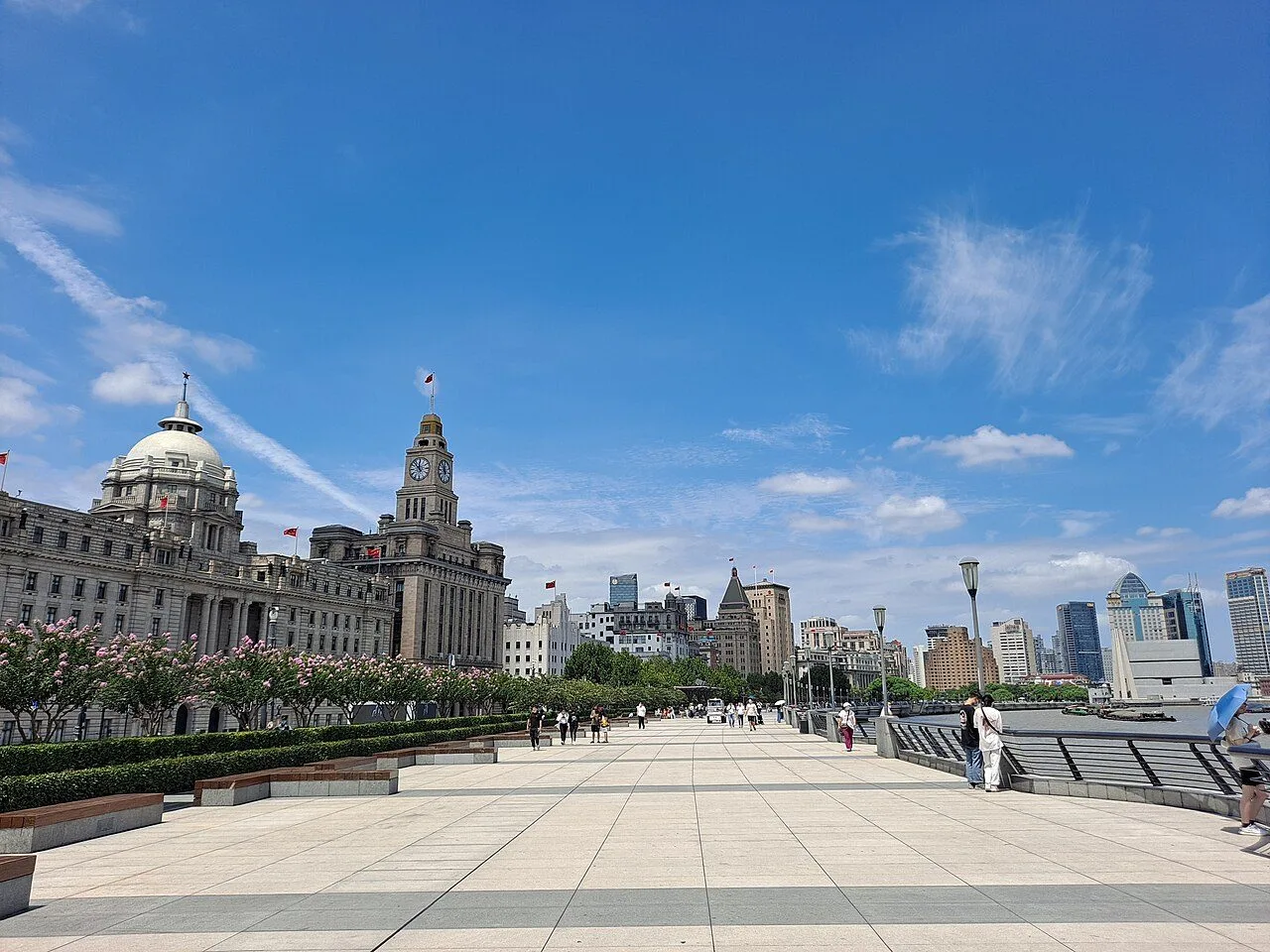 The Bund at night, with the colonial-era buildings lit up in golden light and the Lujiazui skyline across the Huangpu River