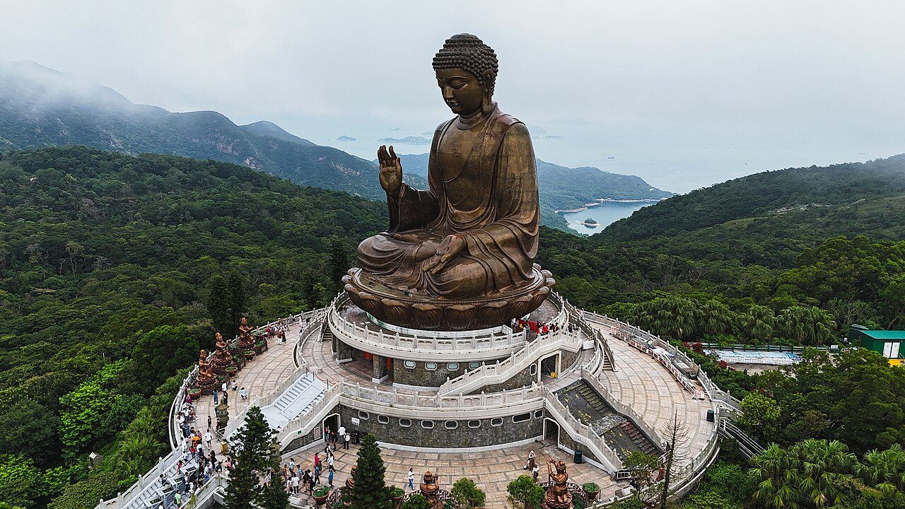 The 34m Tian Tan Buddha bronze statue on Lantau Island, with Lantau mountain ridges behind