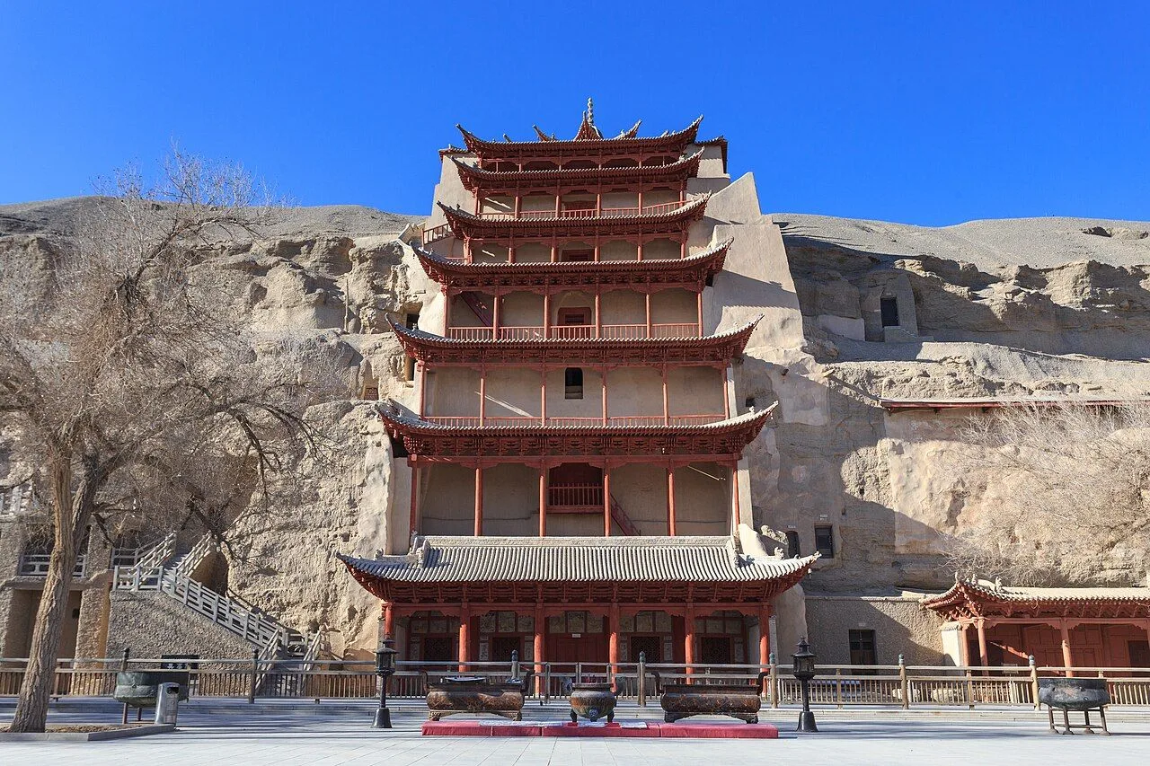 The 9-story pagoda facade at the entrance of the Mogao Caves, Dunhuang — the iconic 1963 reconstruction of the Tang-dynasty wooden pagoda that fronts the world's largest collection of Buddhist cave art (492 caves, 1,000 years of murals)