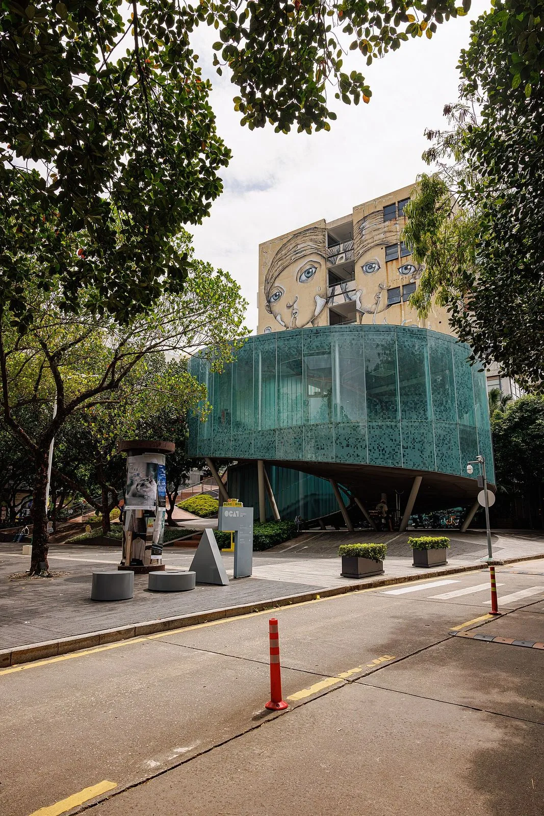 A street art mural at OCT LOFT in Shenzhen — the iconic illustration of a face with multiple eyes on the building facade, by Chinese street artists, the signature visual identity of this converted 1990s industrial complex turned creative district in Nanshan. The complex hosts galleries, design studios, indie cafes, and live music venues