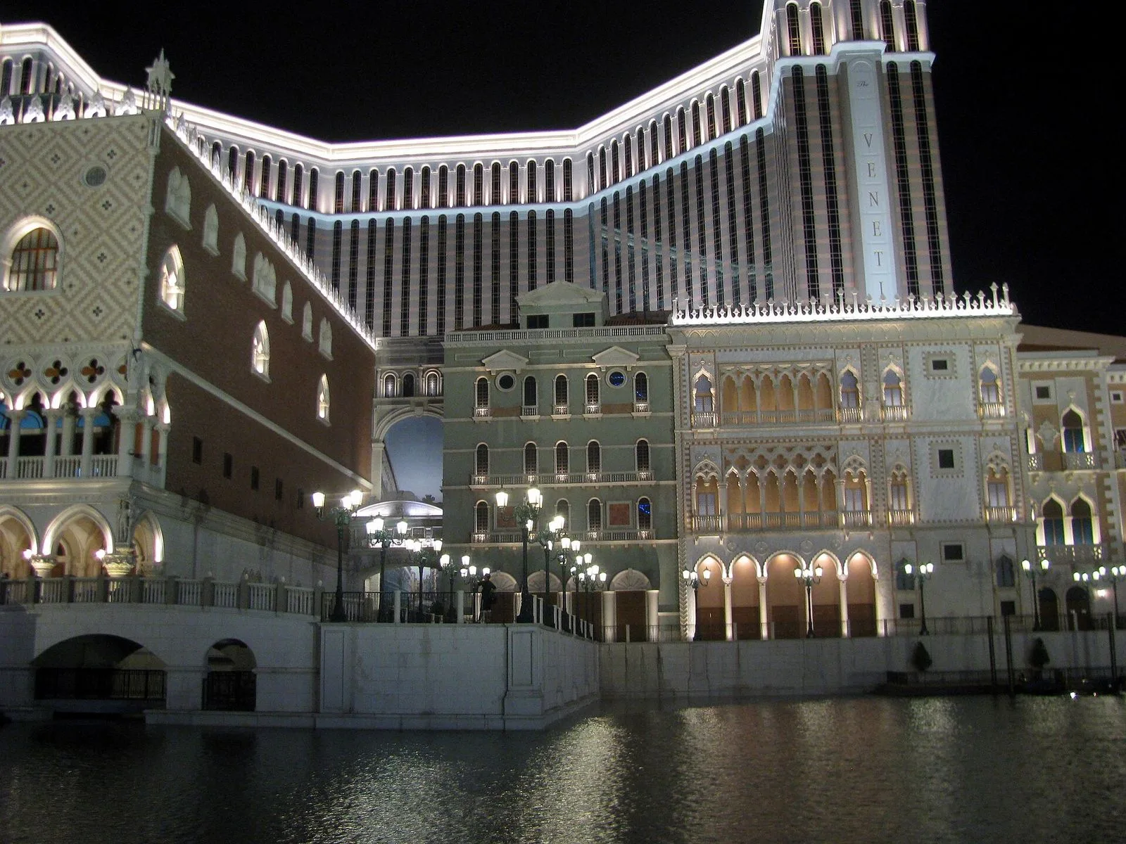 The Grand Canal Shoppes inside The Venetian Macao — the Italianate indoor shopping mall with painted sky ceilings, replica Venetian architecture including the Campanile tower, and the famous indoor canals where gondoliers pole visitors past the luxury stores, the 10 million sq ft integrated resort that is the largest building in Macau by floor area and the 7th-largest building in the world, opened in 2007 at a cost of $2.4 billion by the Las Vegas Sands Corporation