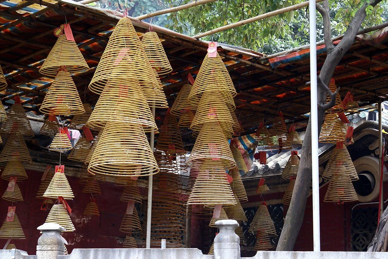 Hanging incense coils at the A-Ma Temple in Macau, the conical spiral incense burners suspended from the wooden rafters filling the prayer hall with smoke — a tradition dating to the 16th century