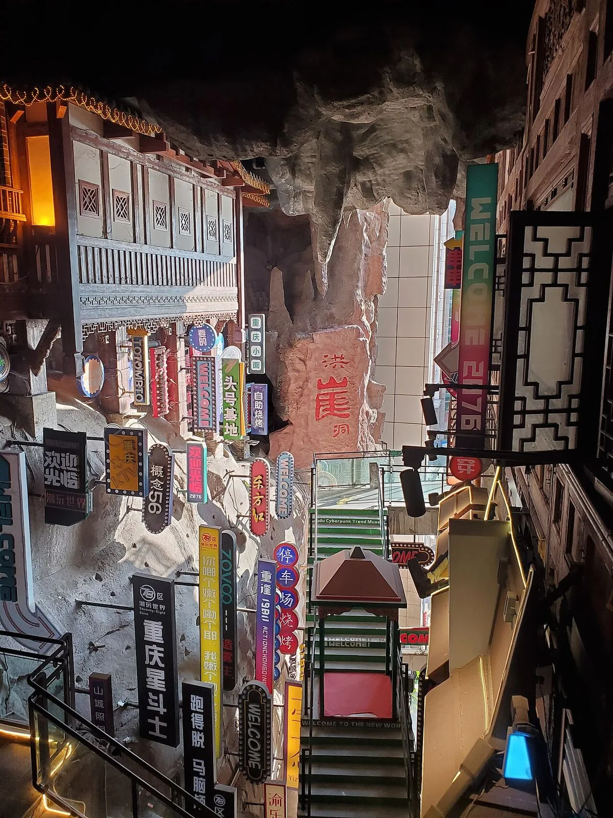 The neon-lit interior of Hongya Cave at night in Chongqing — the cliff face above the pedestrian street, Chinese-language signs and neon everywhere, the cyberpunk atmosphere Chongqing is famous for; 30 million visitors a year come mostly to see this at night