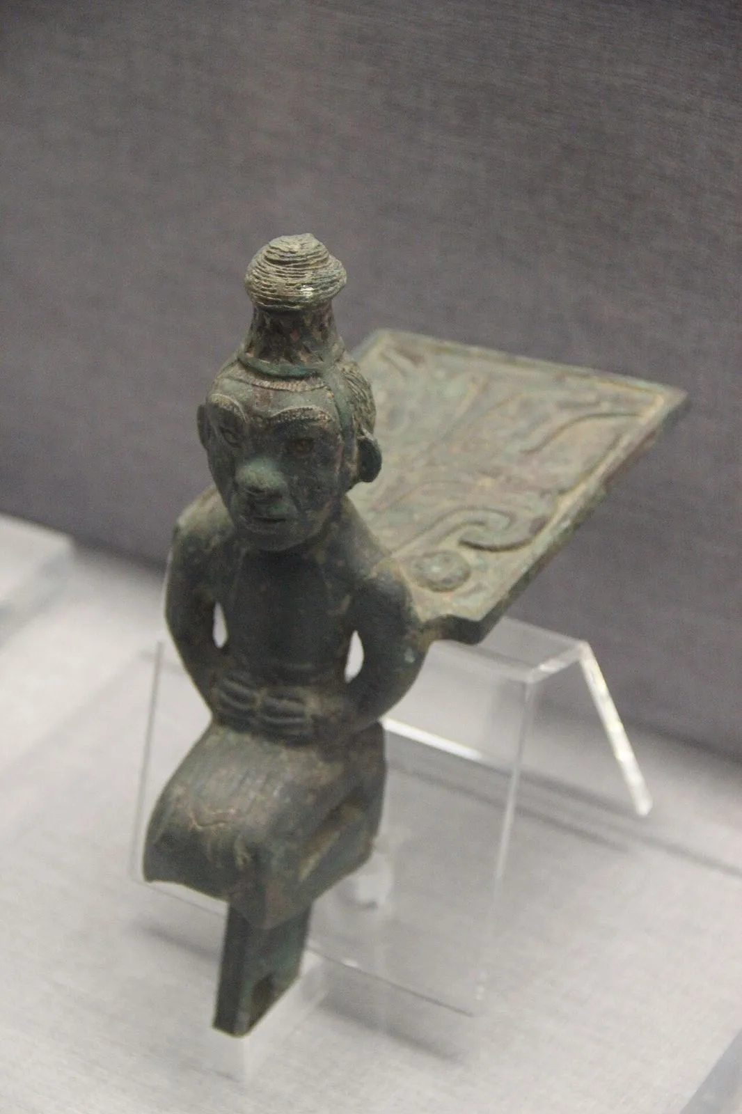 A Western Zhou bronze human figure ornament with elaborate headdress and ceremonial blade — among the 300,000+ artifacts in the He-Luo Civilization collection spanning 100,000+ years of regional history. The He-Luo region around Luoyang was one of the cradles of Chinese civilization