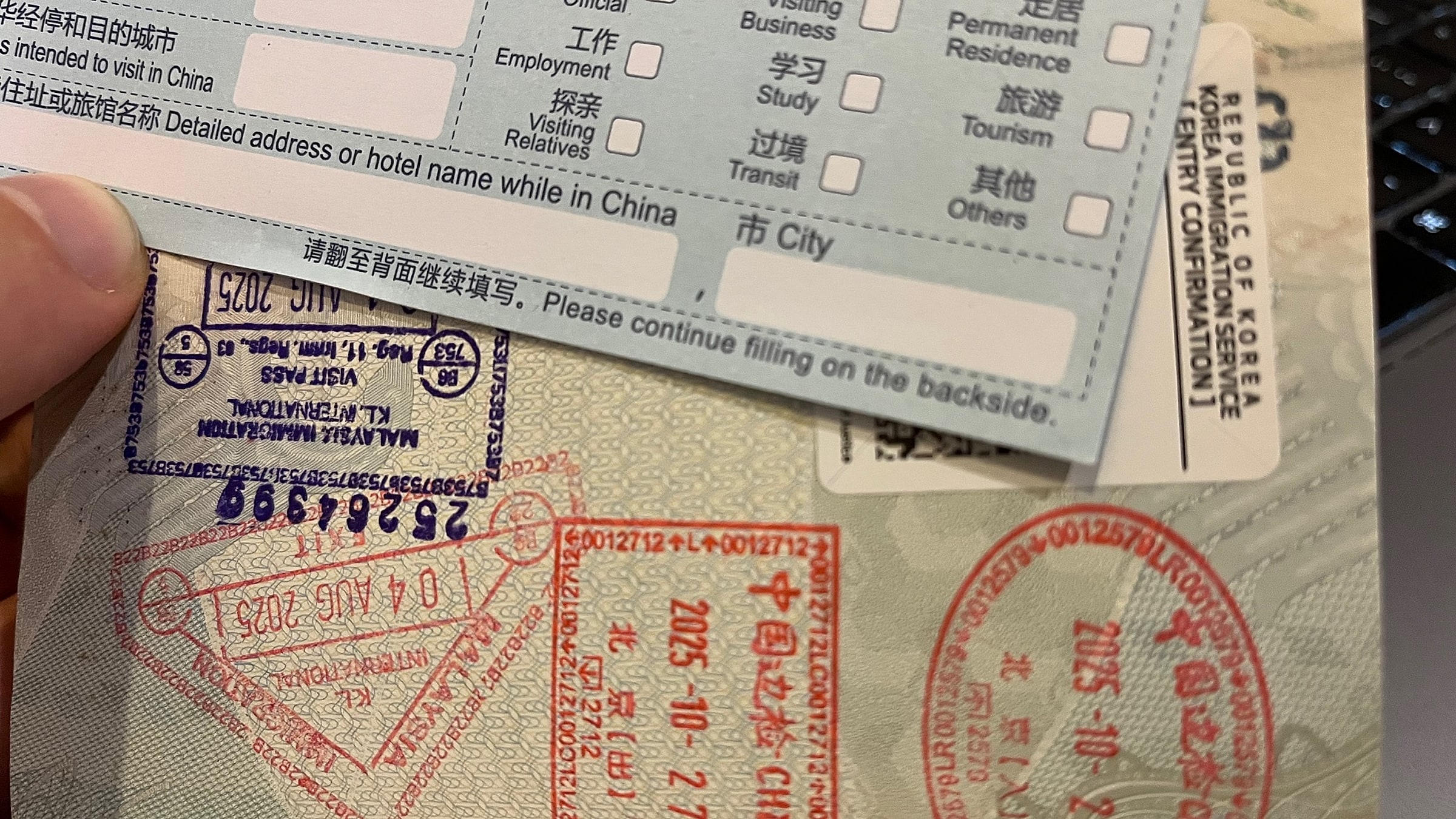 Real Chinese Arrival/Departure Card being filled out — every foreign visitor must complete one of these on the plane or at the immigration counter, with the same fields (Family name, Given names, Passport No., Nationality, Flight No., Address in China, Purpose of visit) regardless of whether you're on a 144-hour or 240-hour permit