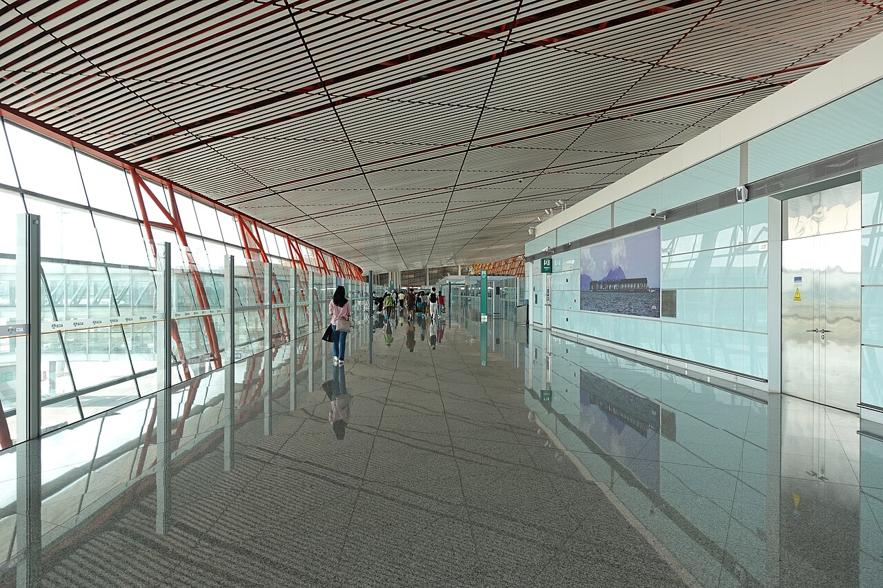 Foreign traveler at Beijing Capital International Airport arrival hall with passport and China visa documents
