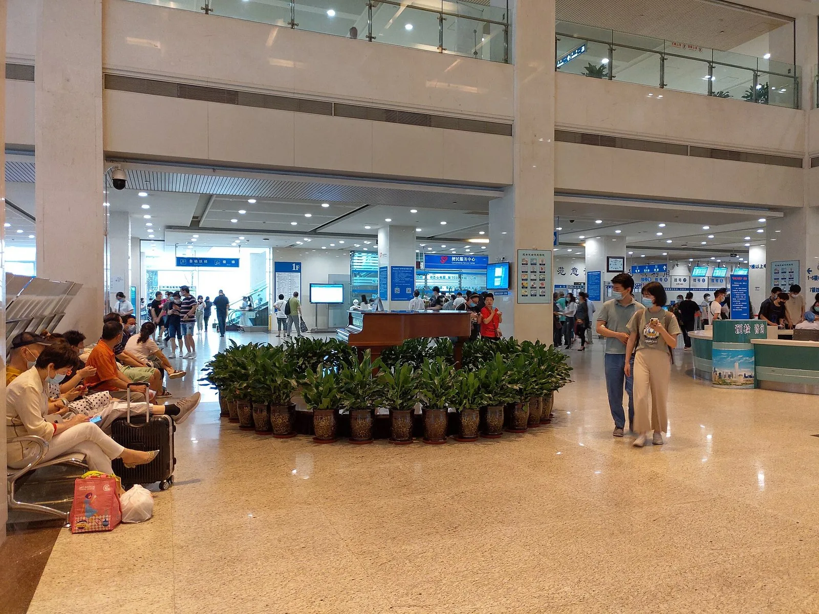 Modern lobby of Shanghai Ruijin Hospital's outpatient department (瑞金医院门诊大厅) — the kind of clean, organized public tertiary-A hospital environment foreign medical tourists encounter in tier-1 cities in 2026, with triage consultation (预检咨询), self-service kiosks, and English-Chinese bilingual signage.