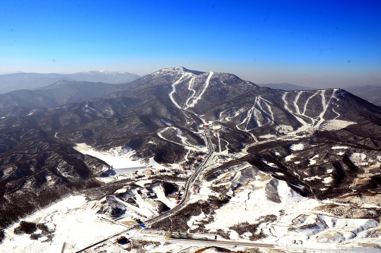 허베이 충리의 완룽 스키 리조트에서 눈 덮인 만리장성 전망을 배경으로 서 있는 외국인 스키어