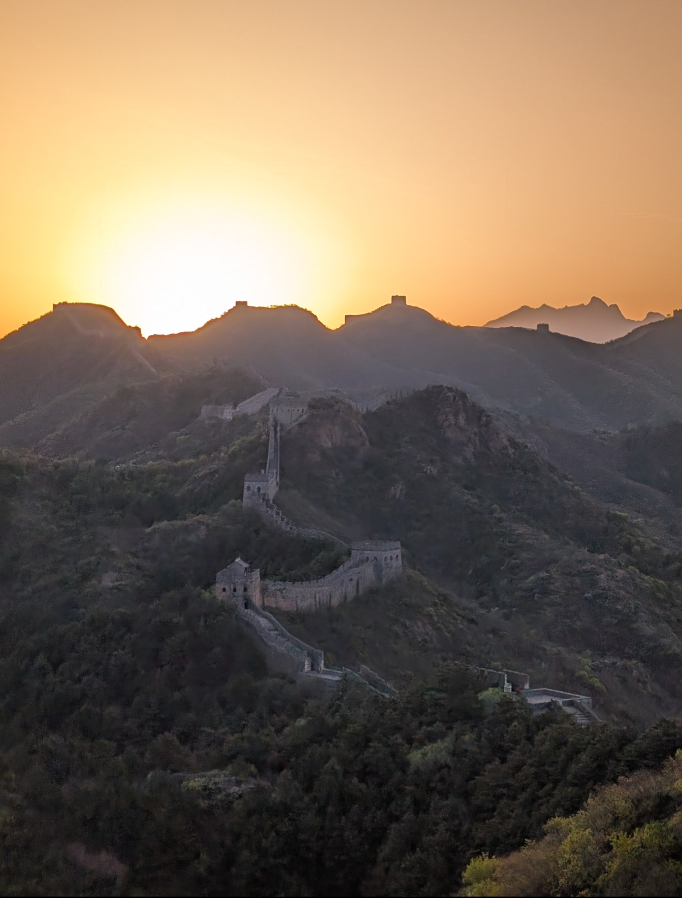 A solo traveler at the Great Wall of China at sunrise