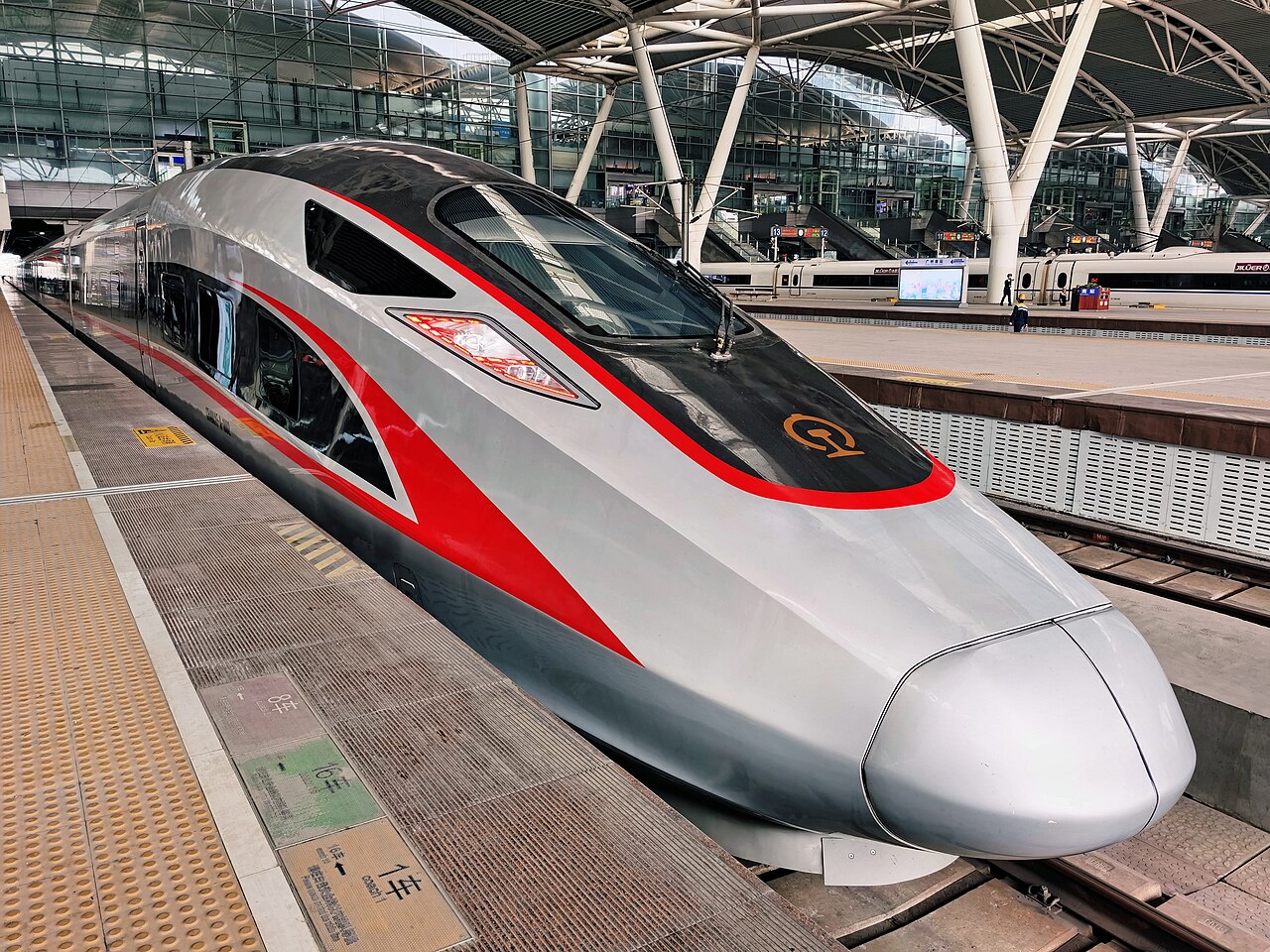 Kereta cepat China CR400AF di stasiun modern, penumpang asing dengan paspor naik