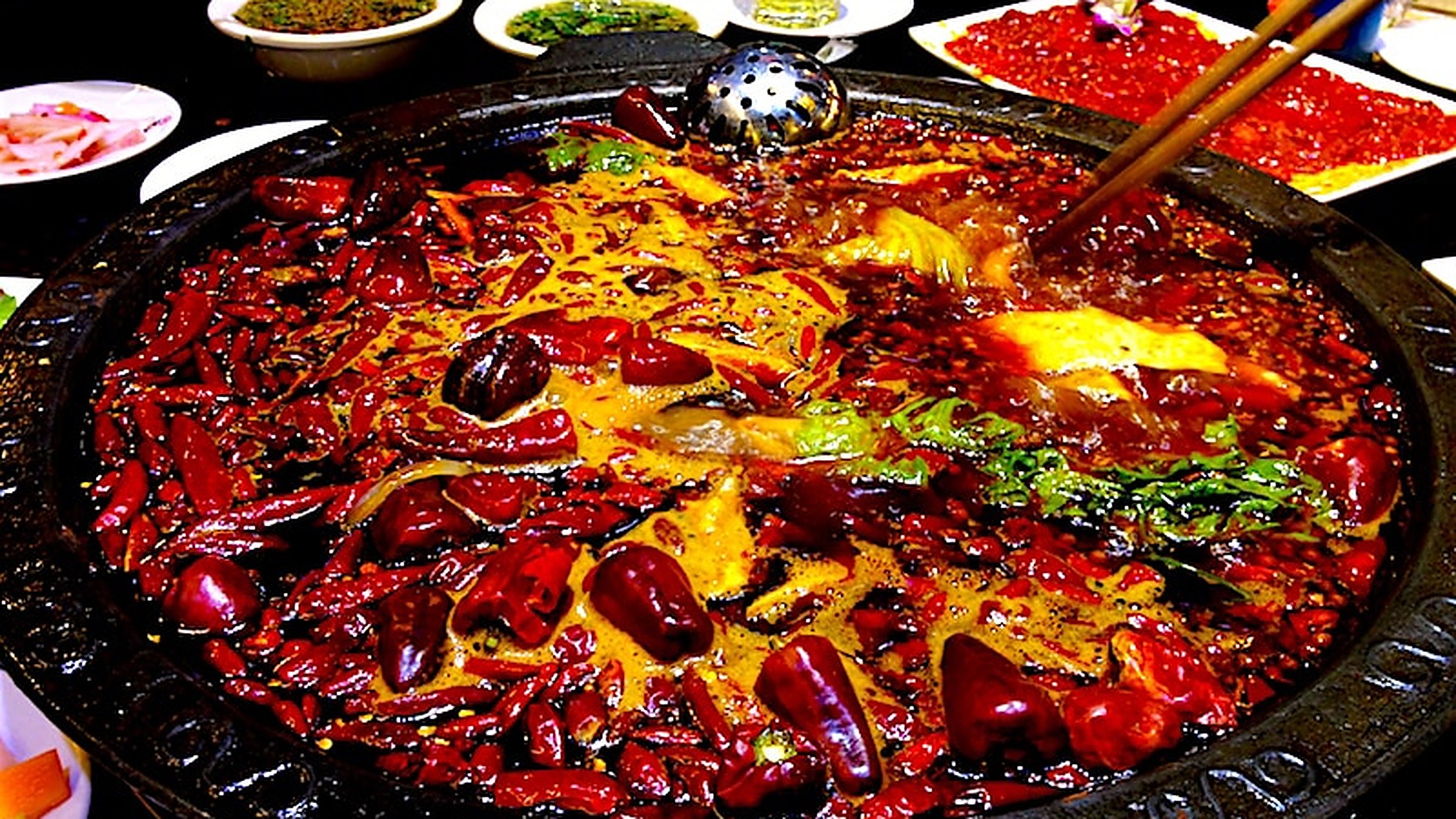 Chongqing hotpot — the city's signature dish: 9-grid mala pot with Sichuan peppercorn and chili.