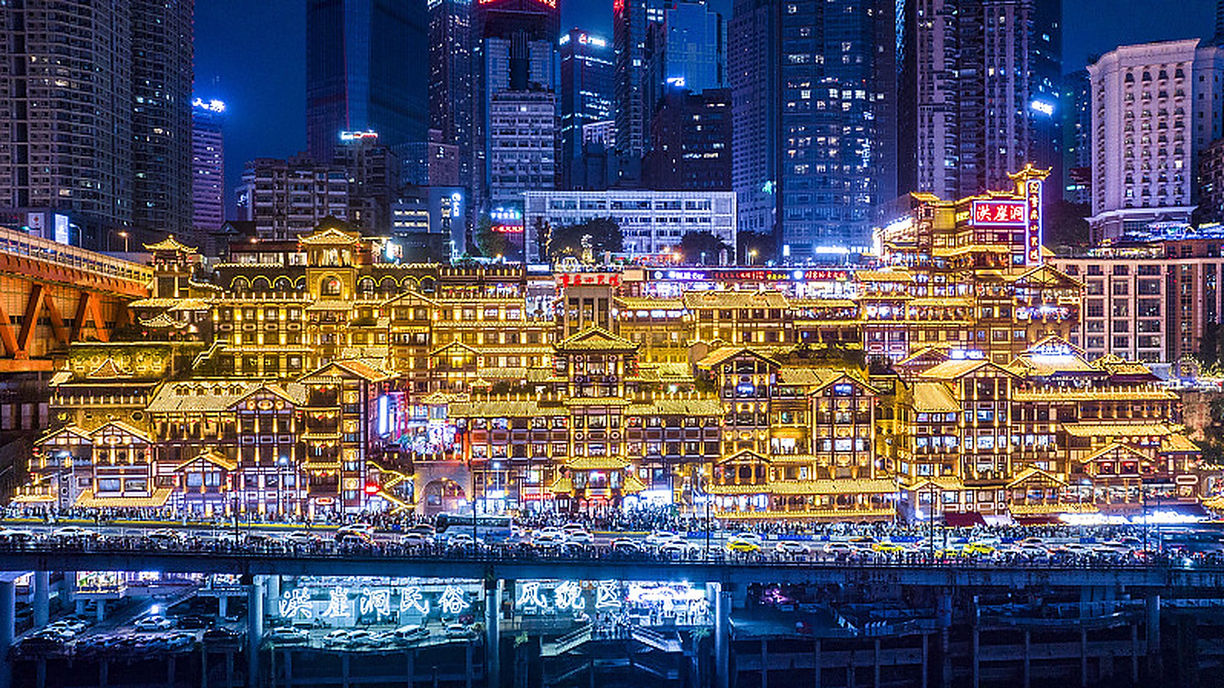 Hongya Cave at night, lit with thousands of LEDs against the Yangtze River and Qiansimen Bridge