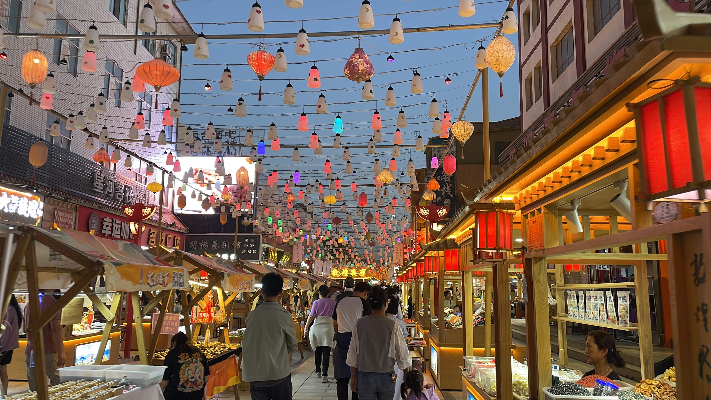 Shazhou Night Market (沙洲夜市) — Dunhuang's iconic evening market around the bell tower, with 200+ stalls serving donkey meat noodles, apricot skin water, and Silk Road handicrafts.