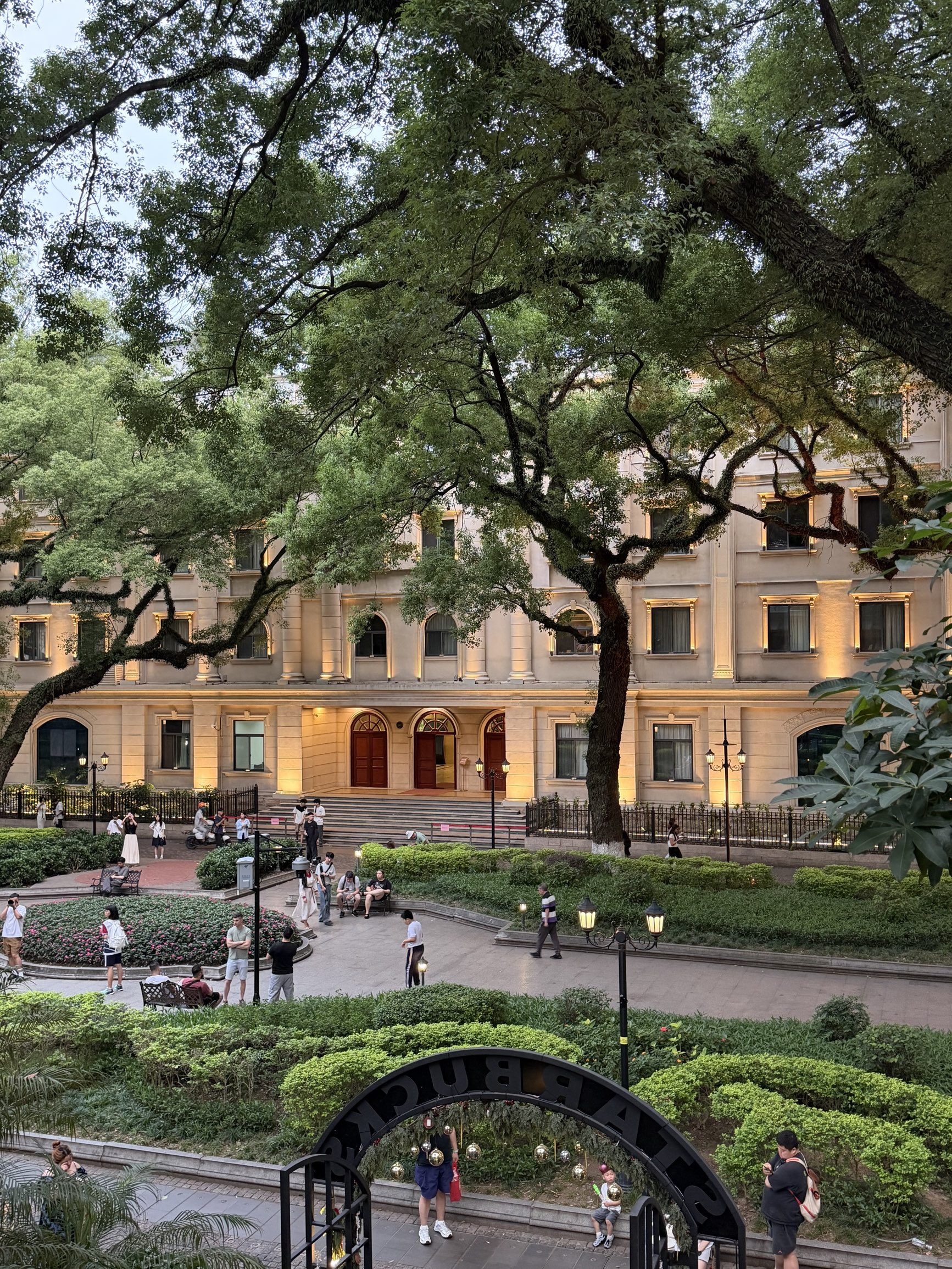Shamian Island — colonial-era white and yellow buildings with shuttered windows, surrounded by banyan trees, on a quiet Guangzhou morning
