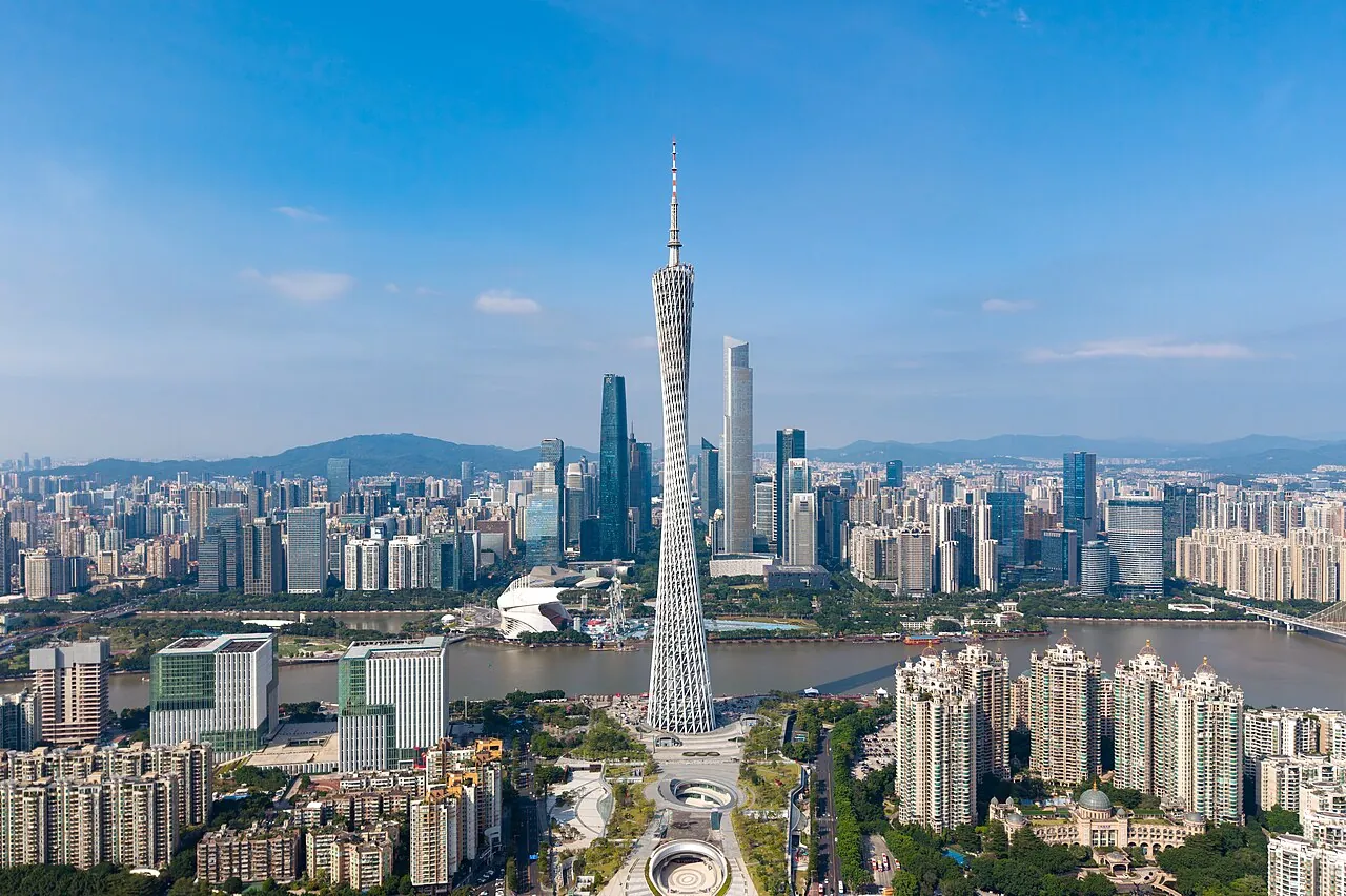The 600-meter Canton Tower rising above the Zhujiang New Town skyscrapers and the Pearl River in Guangzhou, shot on a clear day from across the water.