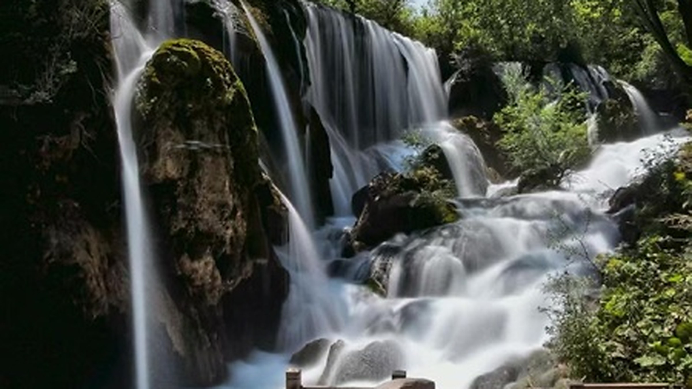 Shuzheng Lakes (树正群海) — a chain of 19 terraced lakes in the Shuzheng Valley connected by waterfalls, with wooden walkways weaving through forest and old Tibetan villages.