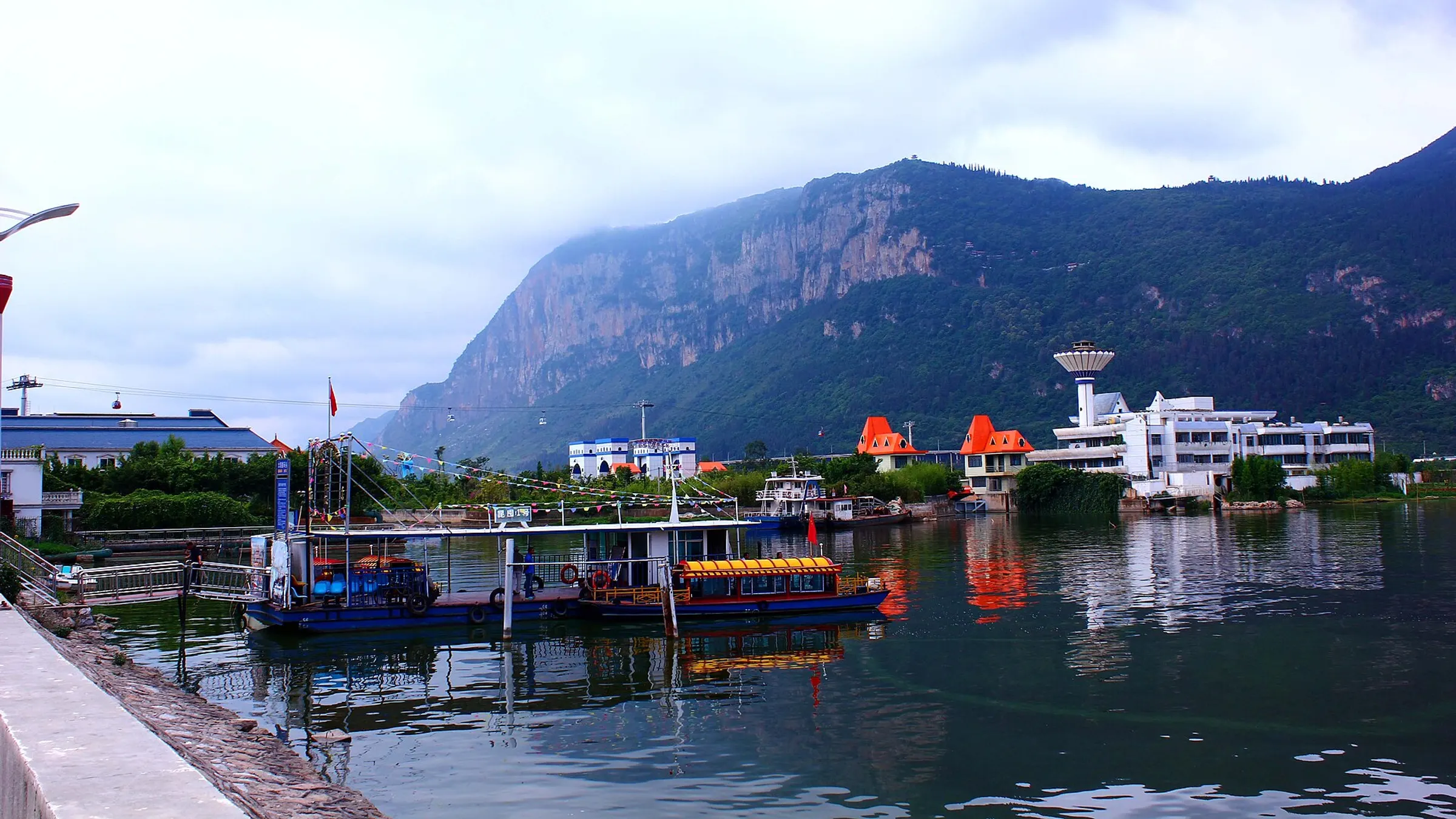 The Western Hills ridge rising above Dianchi Lake — the cliff face where the Dragon Gate grottoes are cut.