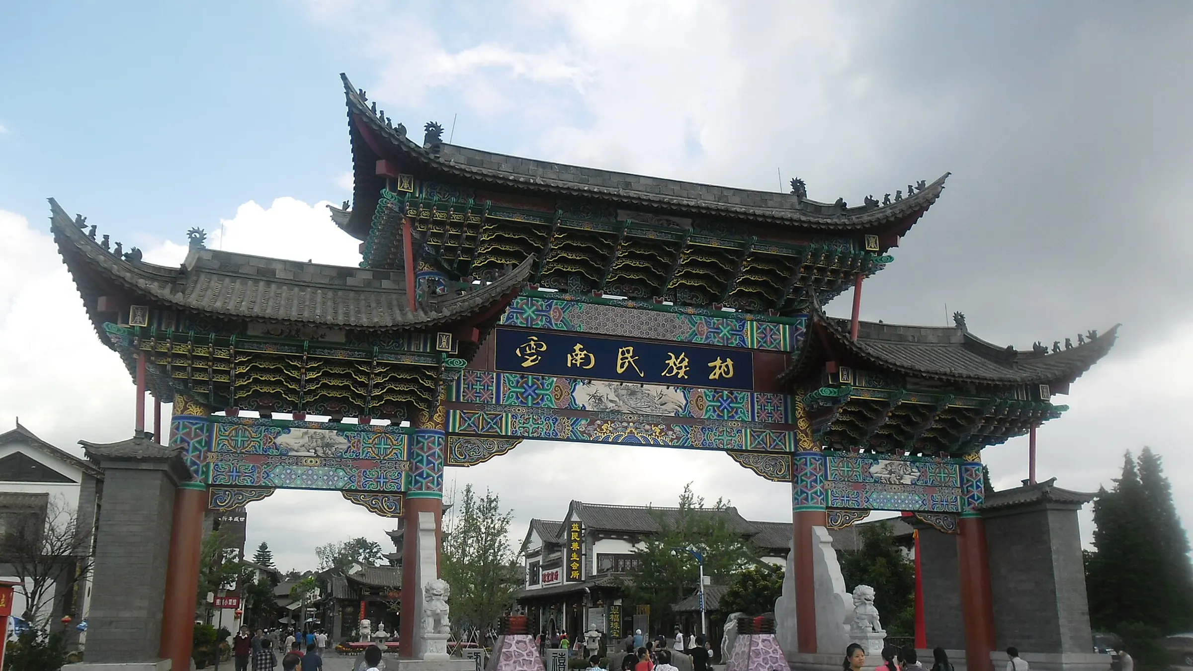 The entrance archway of the Yunnan Nationalities Village, a curated park of 26 ethnic groups on the Dianchi shore.