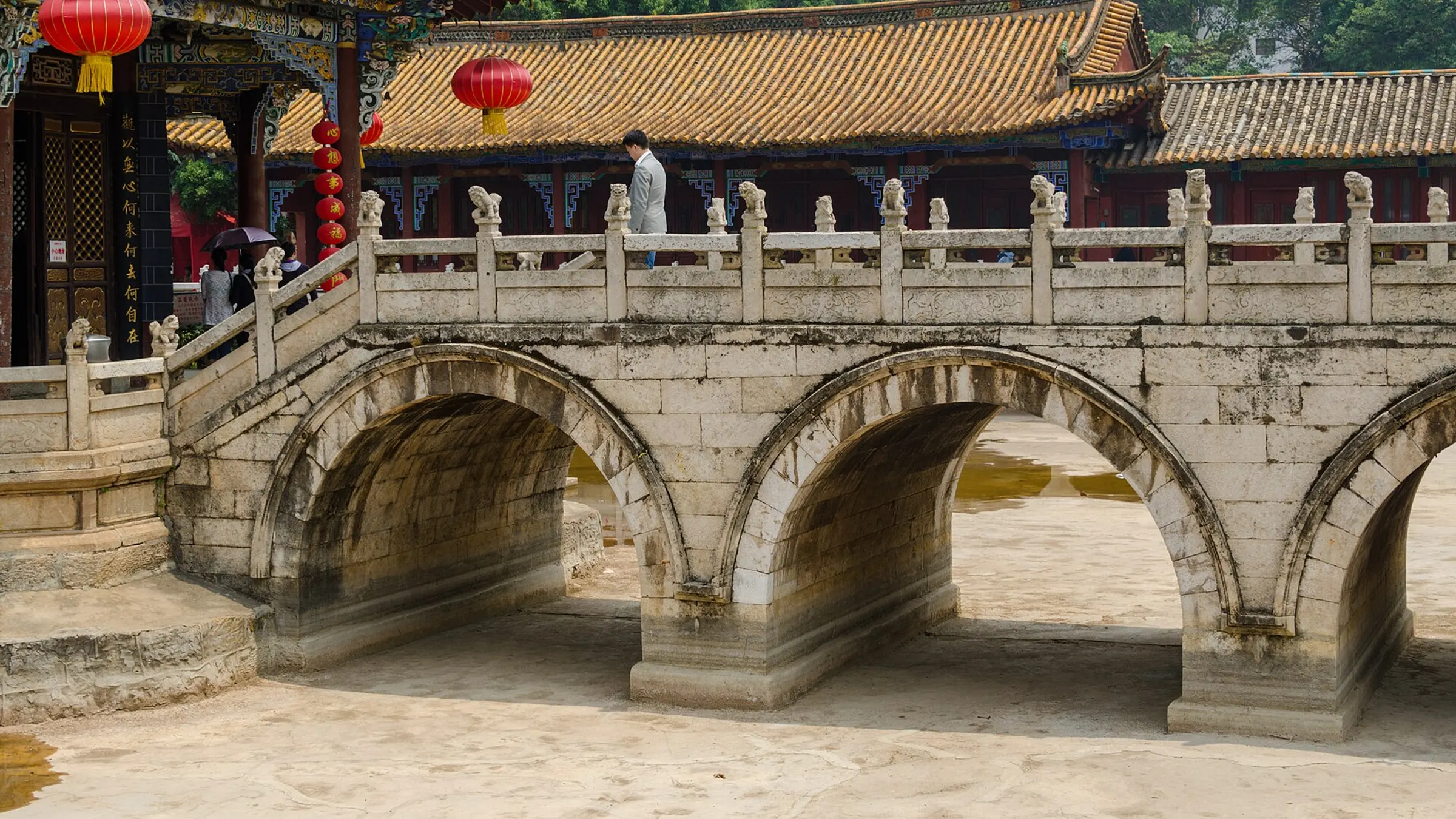 Yuantong Temple's golden-tiled halls and stone bridge — the calmest hour in central Kunming.