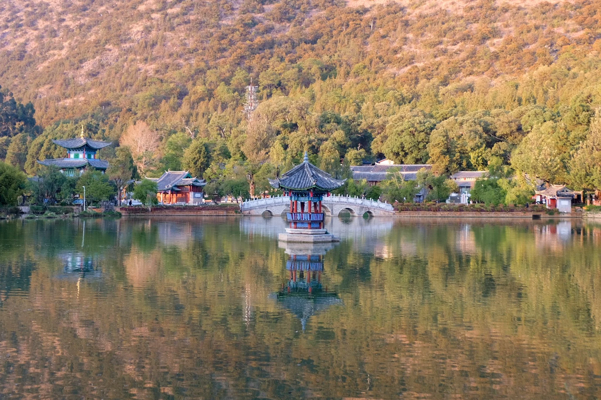 Black Dragon Pool (黑龙潭) — a crystal-clear spring at the foot of Jade Dragon Snow Mountain, with the Moon-Embracing Pavilion and the snow-capped peak reflected in the water.