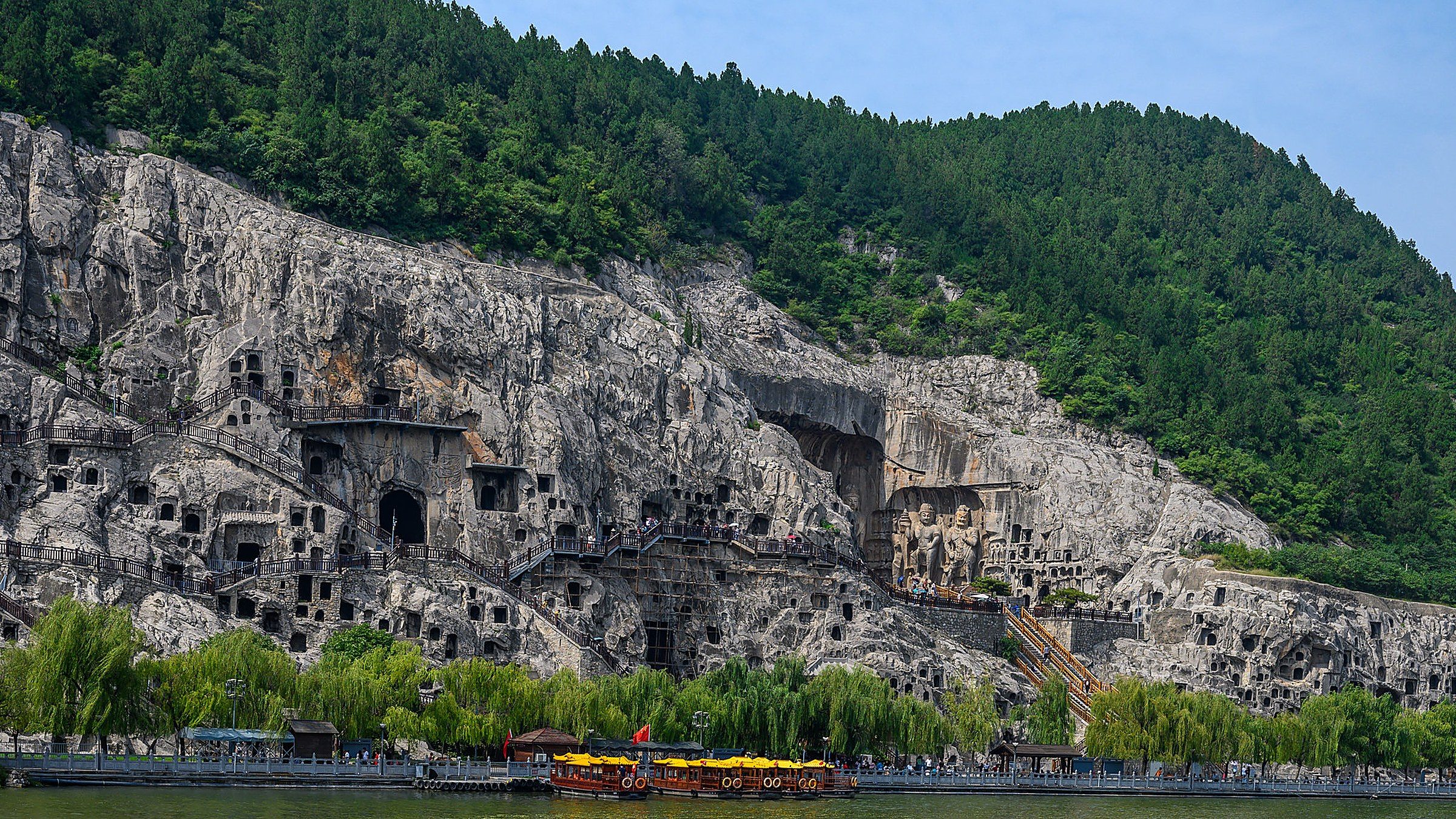 Une rangée de sanctuaires de grottes bouddhistes aux grottes de Longmen, sculptés dans les falaises calcaires le long de la rivière Yi.