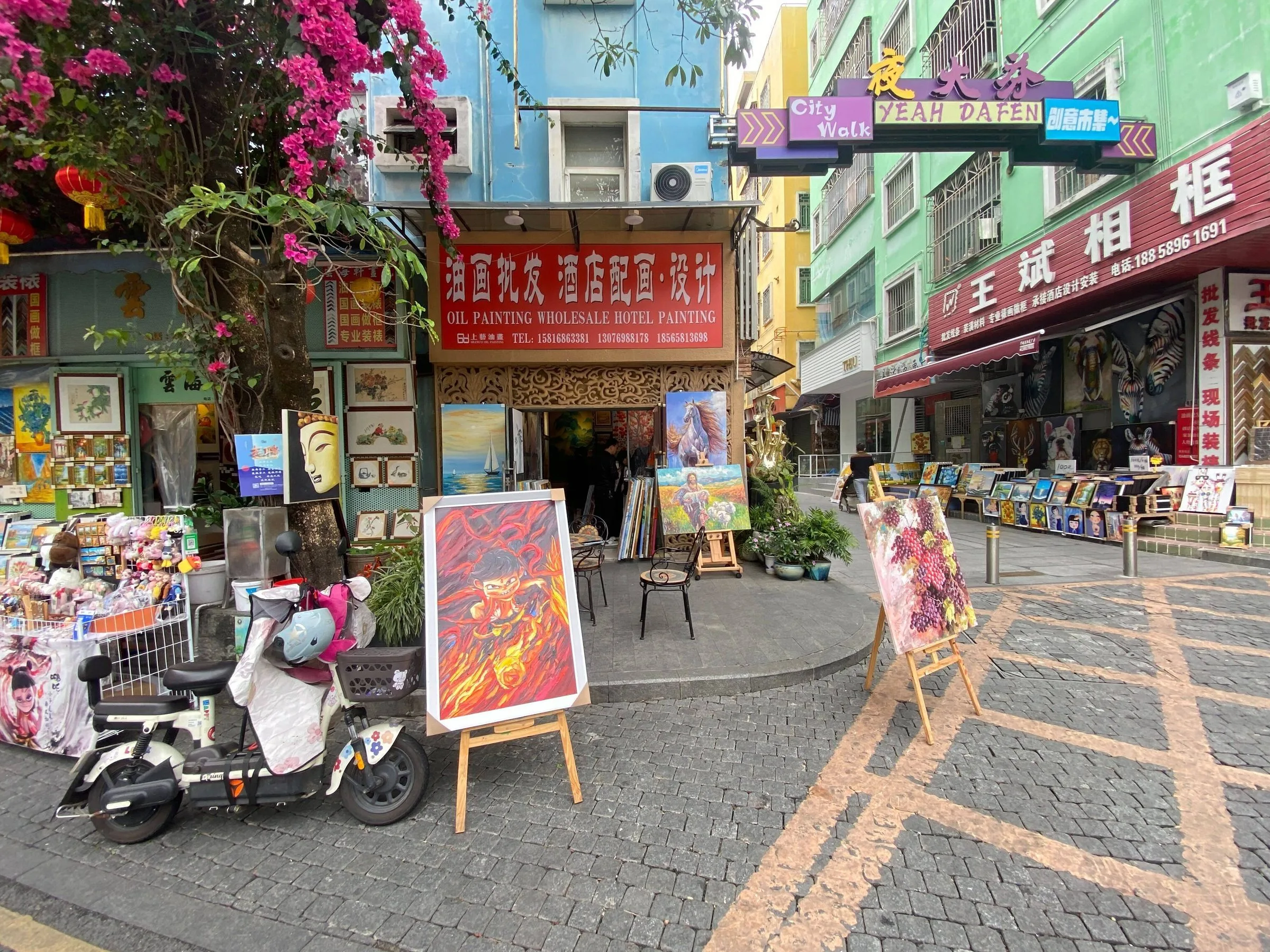 Dafen Oil Painting Village — paintings displayed outside studios in a Shenzhen suburb.