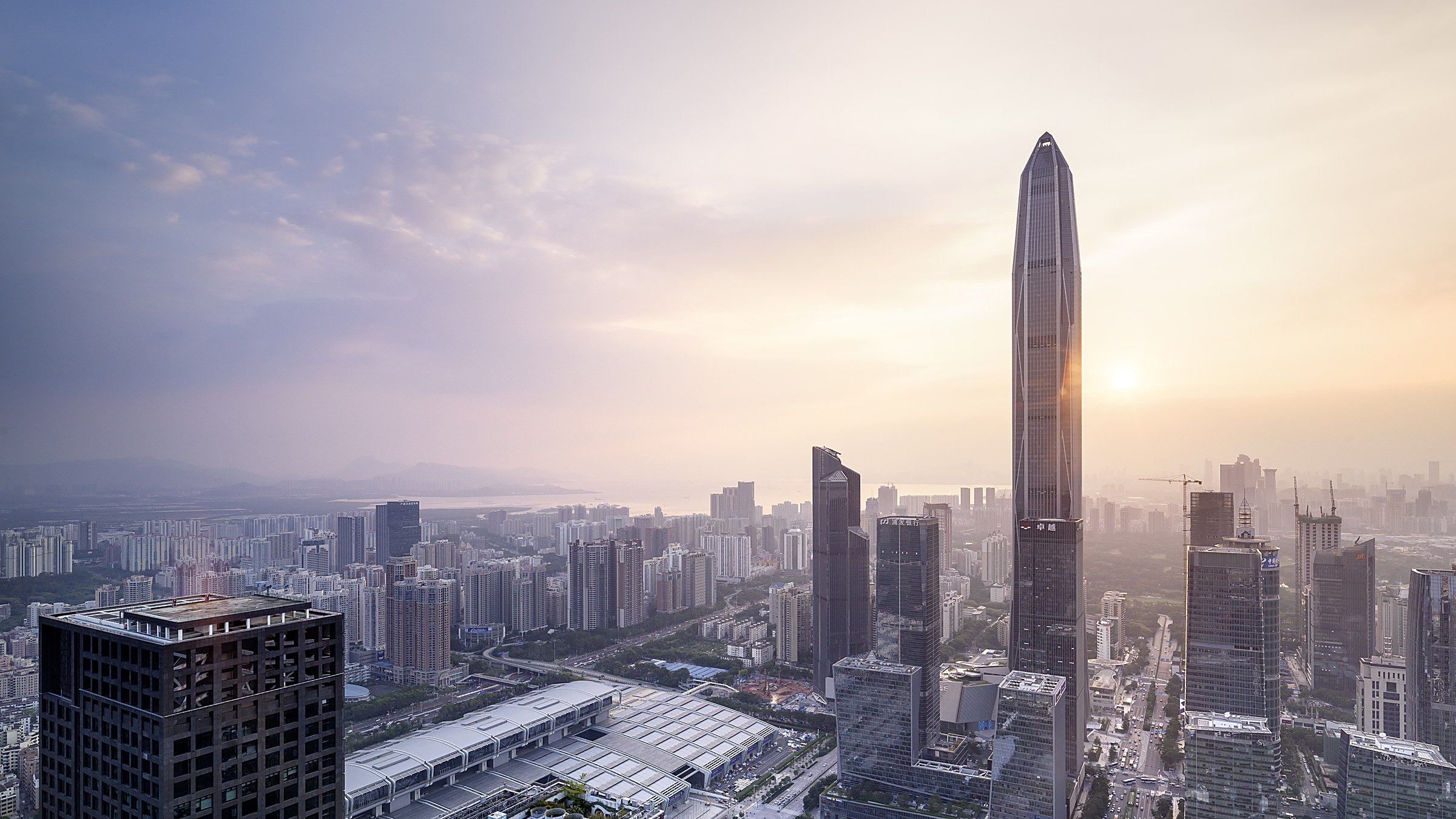 Ping An Finance Centre at night — a 599m skyscraper lit in white and blue, with the Shenzhen skyline and bay in the foreground