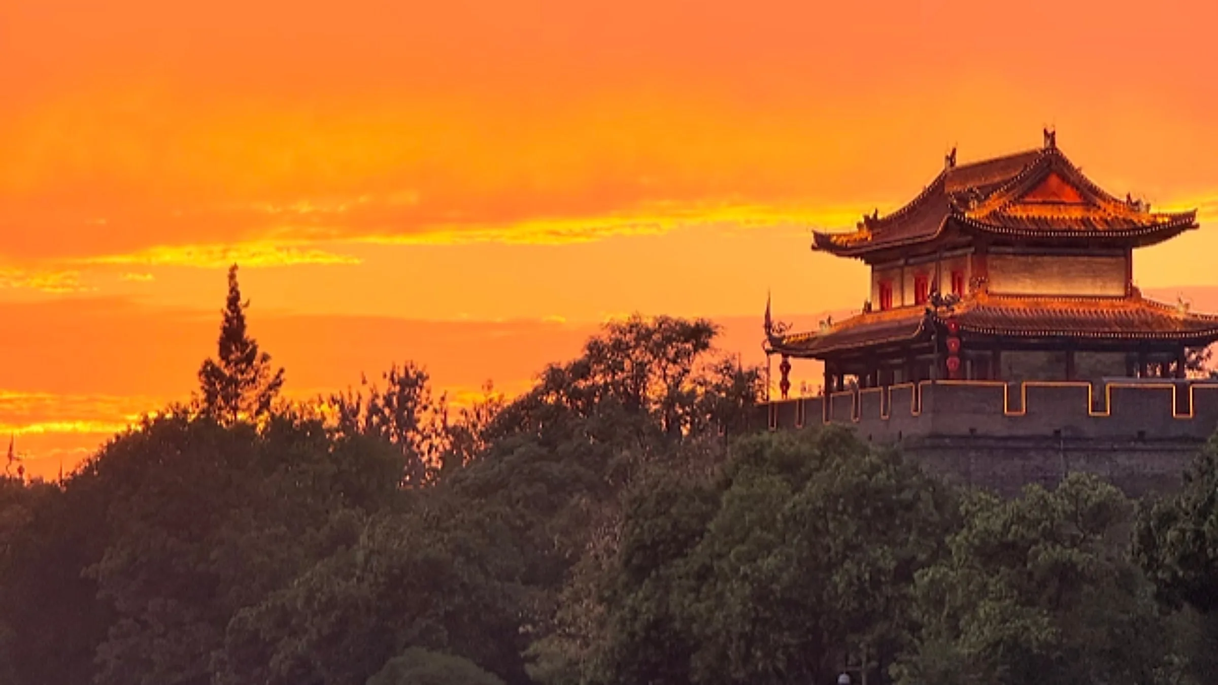 Xi'an City Wall at sunset — the 13.7 km Ming-dynasty fortification with the Bell Tower in the distance