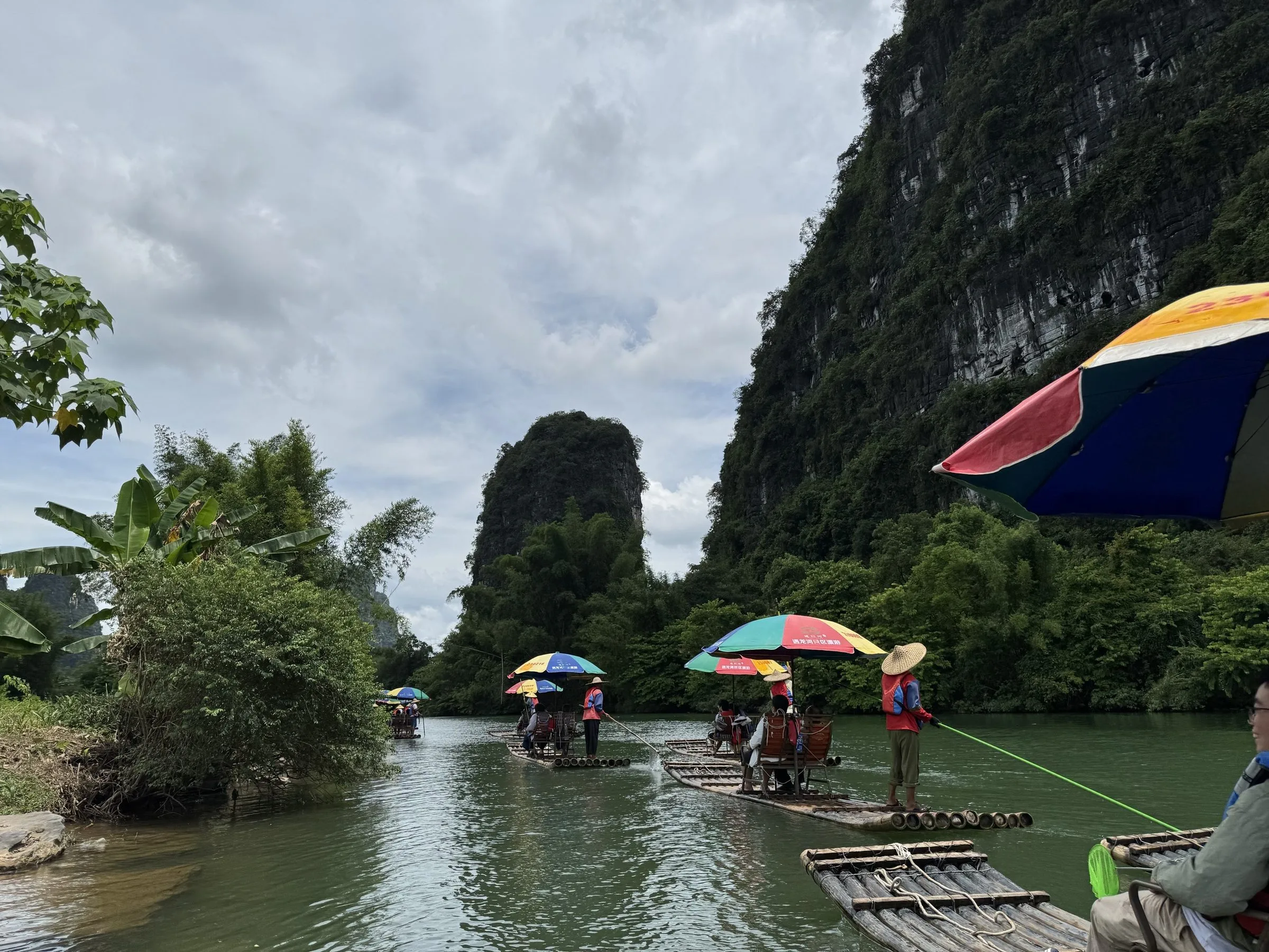 Yulong River bamboo rafting (遇龙河) — a 2-hour bamboo raft ride down the smaller and more intimate Yulong River, with 8 traditional weirs and karst-peak views.