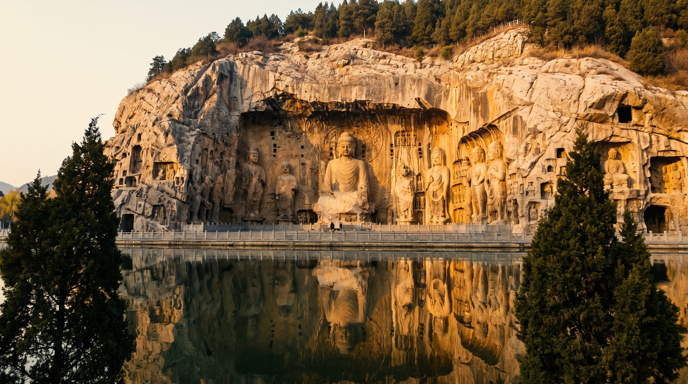 The Fengxian Temple niche at the Longmen Grottoes in Luoyang, with a 17-meter-tall Vairocana Buddha statue flanked by disciples and guardians carved into the limestone cliff