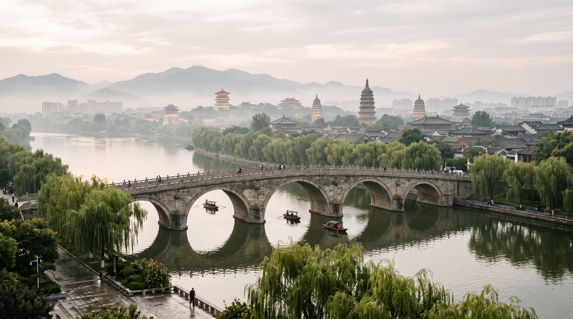 Visitors crossing the stone footbridge over the Yi River at the Longmen Grottoes in Luoyang, with the East Side cliffs visible in the background