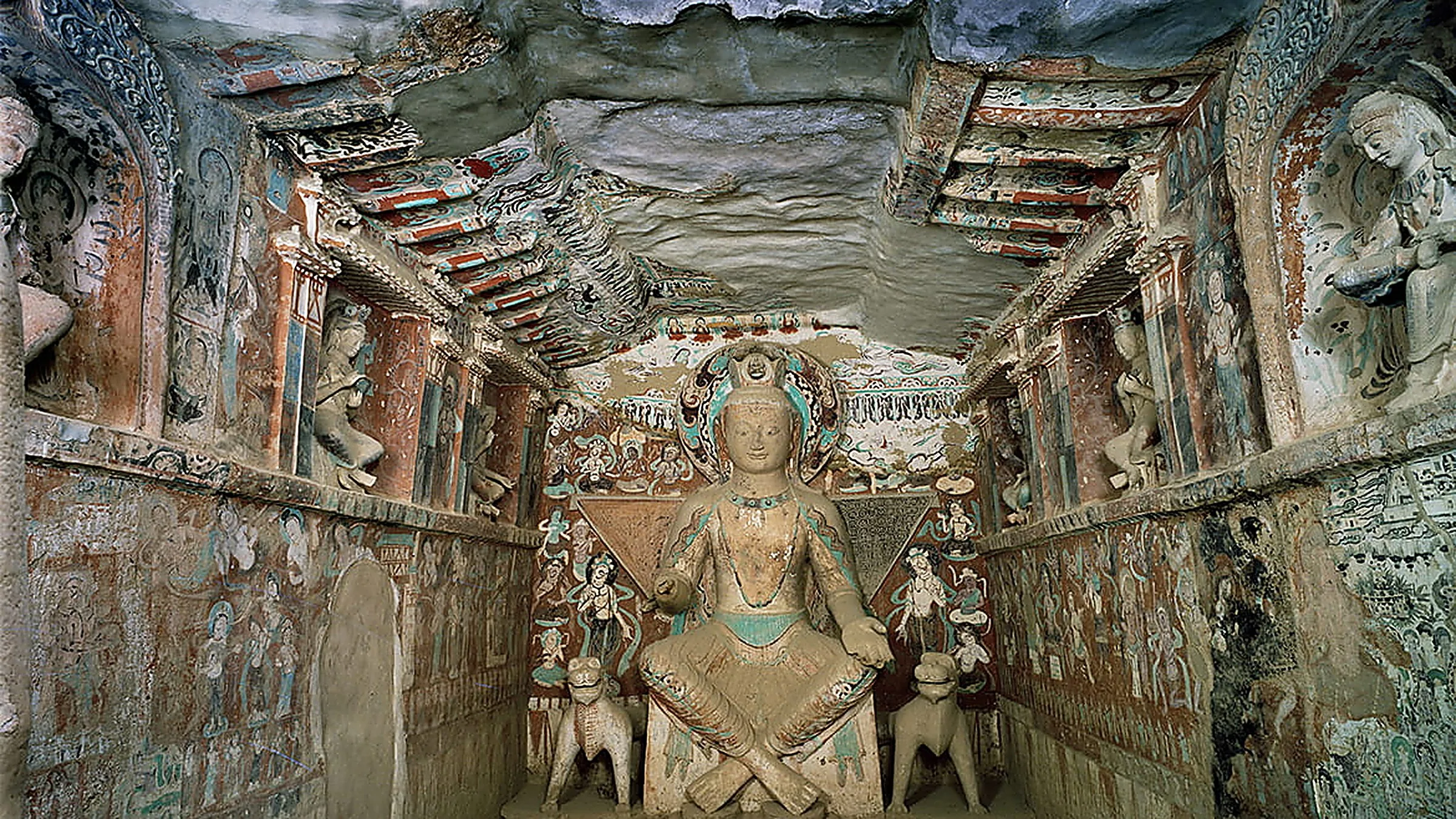 Interior Gua Mogao 9 di Dunhuang, Gansu, dengan mural Buddha akhir-Tang yang menutupi dinding dan langit-langit, menampilkan figur Buddha pusat yang dikelilingi oleh bodhisattva dan figur pendonor yang dilukis dengan pigmen warna tanah